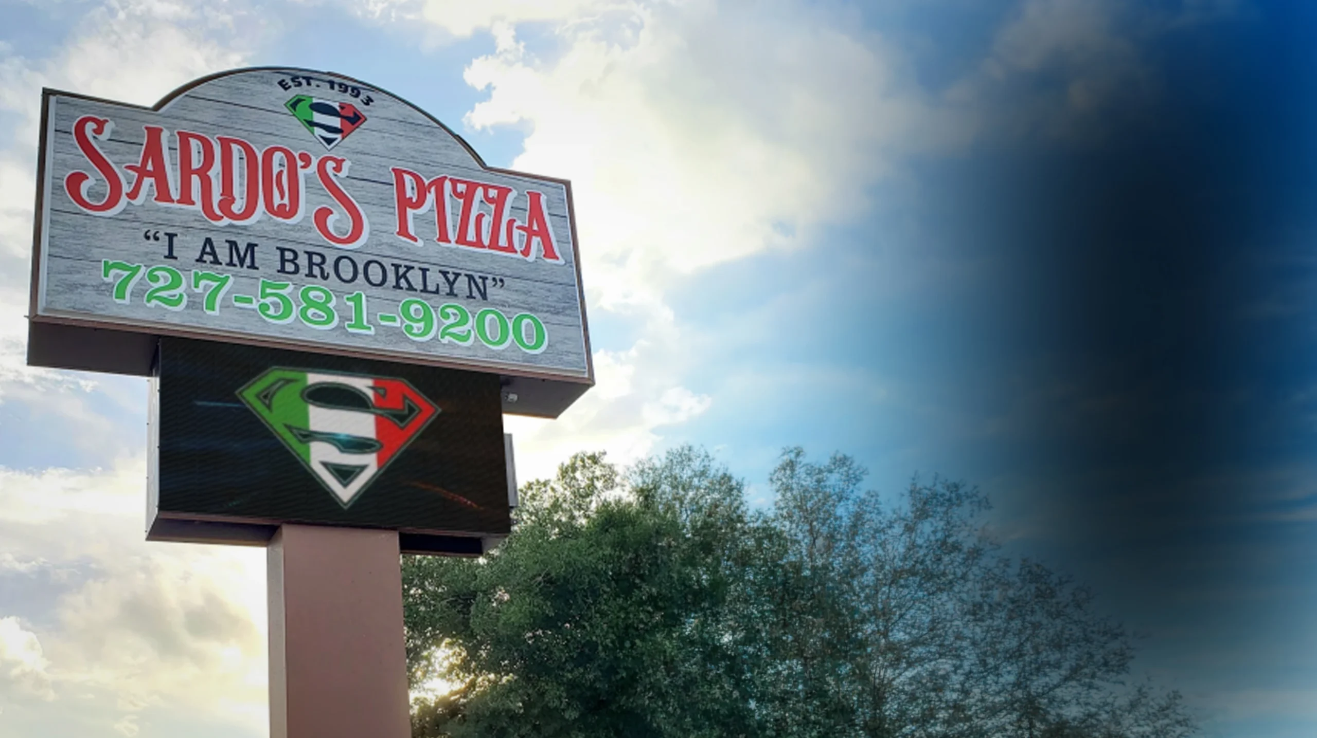 Sardo’s Pizza roadside sign with a digital display beneath the restaurant name in Largo, Florida.