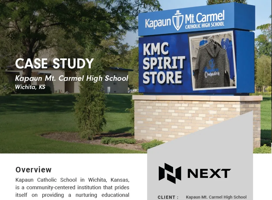 An LED electronic message center displays information for Kapaun Mt. Carmel Catholic High School in Wichita, KS, situated beside a solid-state aluminum KMC Spirit Store sign and surrounded by landscaped greenery. The lower section of the main sign presents case study details and an overview of the school.