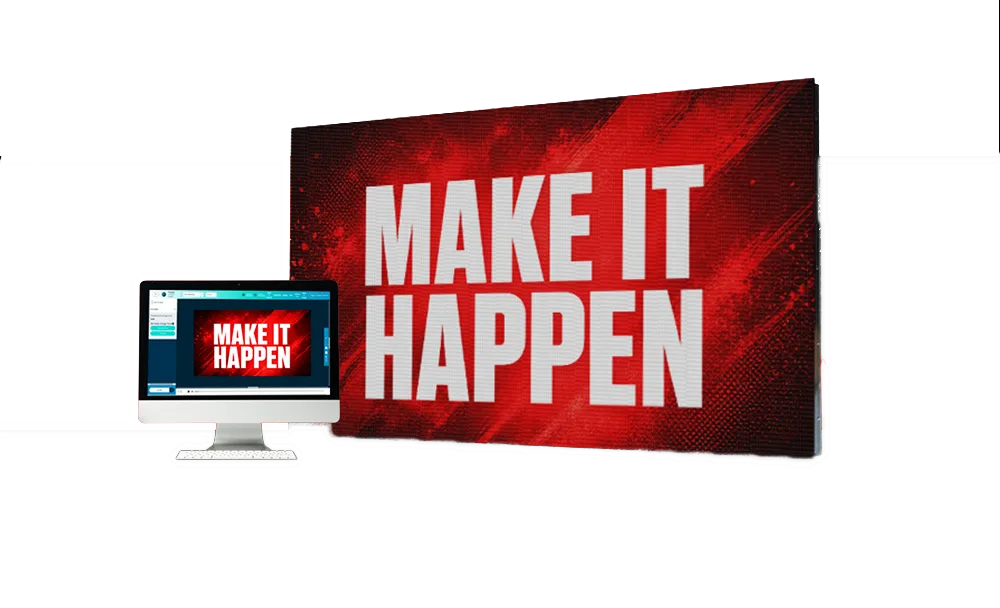 A computer monitor presents a slide reading MAKE IT HAPPEN in bold white letters on a red background, mirroring a larger high-brightness LED sign or electronic message center behind it that displays the same text.