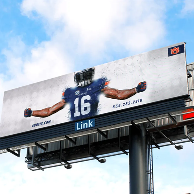 LED electronic message center displays a football player in uniform number 16, arms outstretched and wearing a helmet. The sign features aubfix.com, a contact phone number, and the Auburn University logo in the top right corner, all against a cloudy sky background.