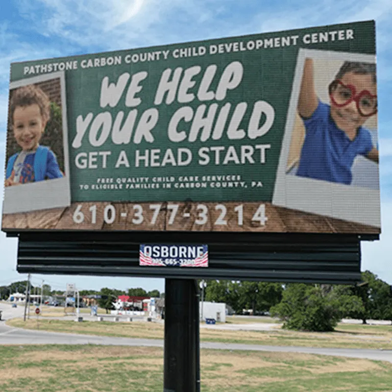 LED electronic message center for Pathstone Carbon County Child Development Center, featuring high-brightness display with images of two smiling children, promoting childcare services. Includes phone number 610-377-3214. Solid-state sign is installed outdoors beside a roadway.