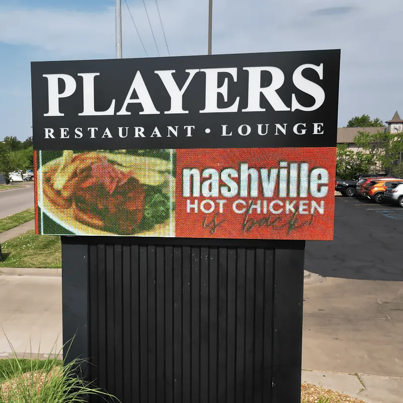 An LED electronic message center sign displays "PLAYERS RESTAURANT • LOUNGE" above high-brightness images of fried chicken and the phrase "nashville HOT CHICKEN." The solid-state, outdoor sign is installed near a parking lot.