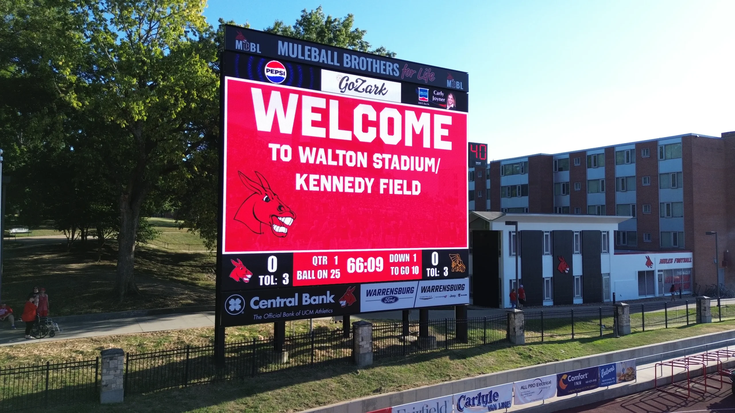 Walton Stadium LED scoreboard displaying Welcome to Walton Stadium/Kennedy Field above football game information.