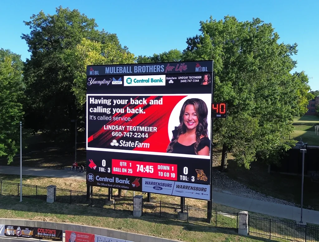 Walton Stadium digital scoreboard displaying sponsor advertising during a football game