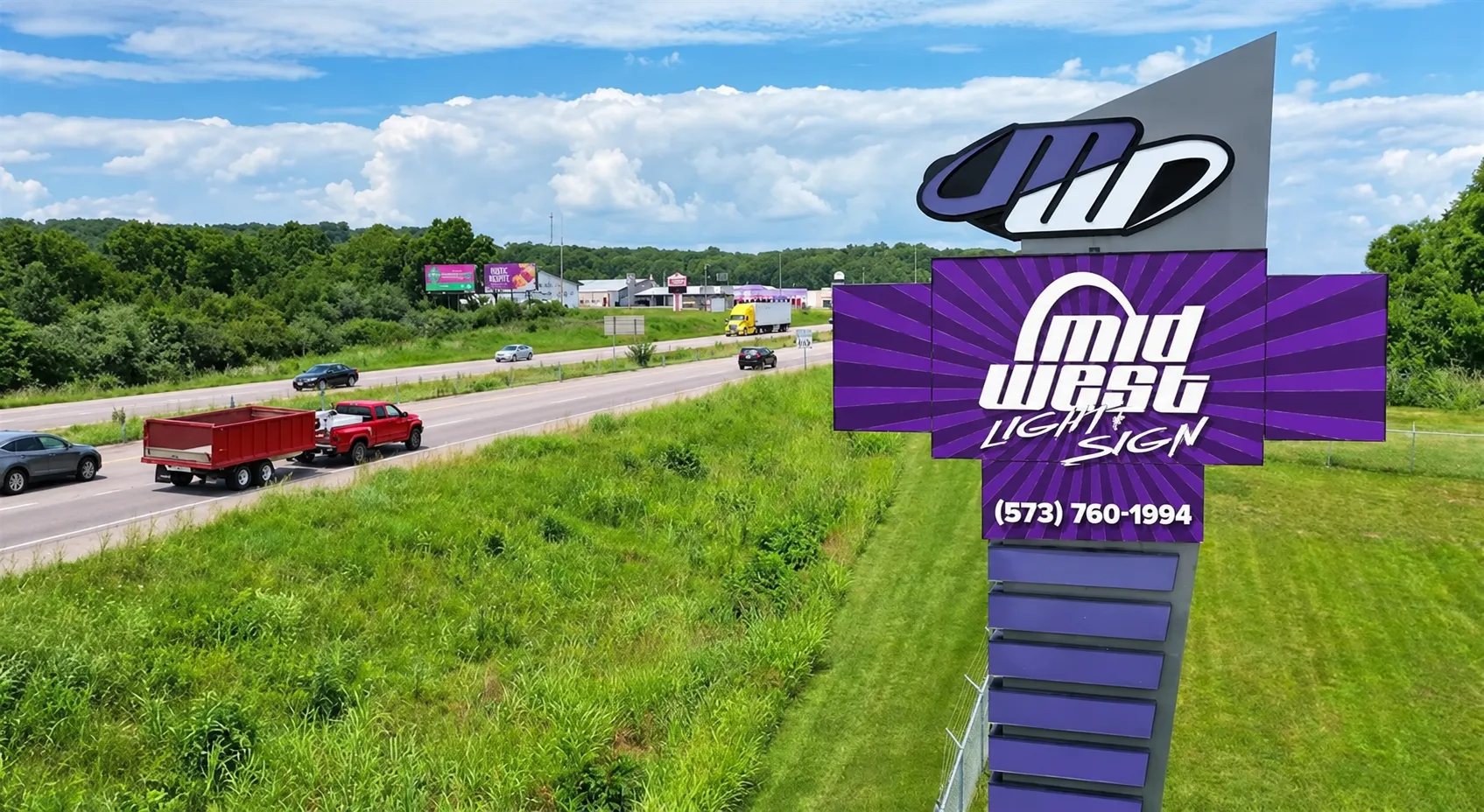 Midwest Light & Sign roadside LED display showing purple business graphics beside highway traffic in Farmington, Missouri.