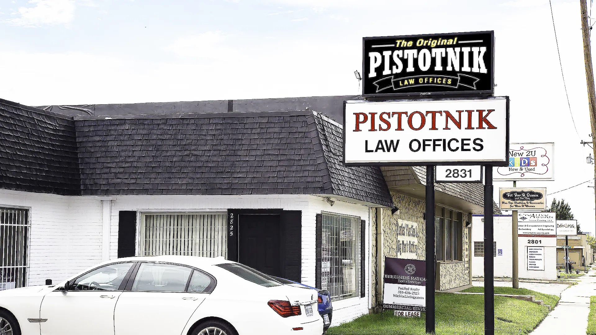 Pistotnik Law Offices pole sign displaying “Pistotnik Law Offices” beside the office building, with parked white cars and the number 2831 below the display.