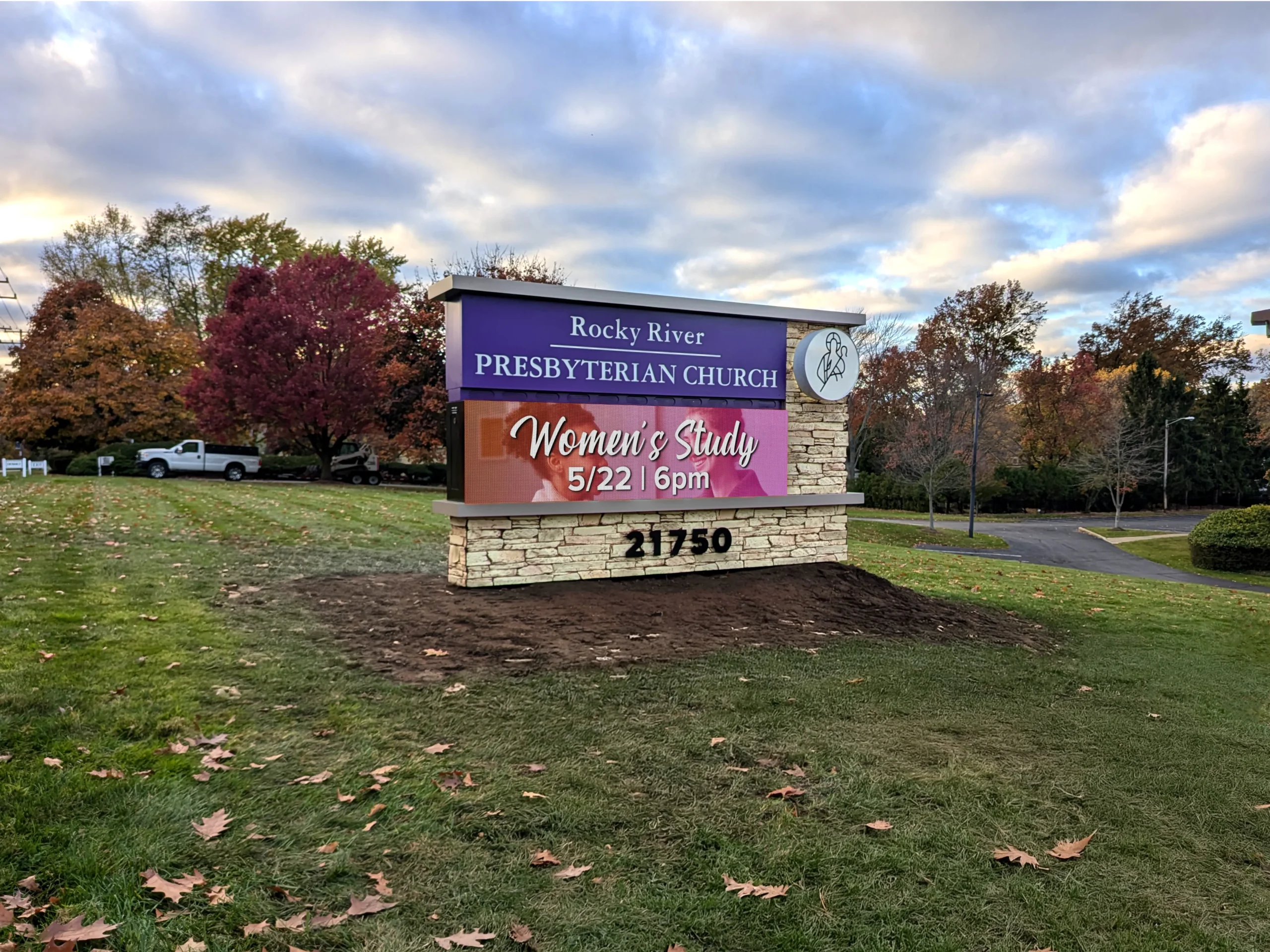 Rocky River Presbyterian Church stone monument sign with a purple name panel and an LED display promoting a women’s study, surrounded by autumn trees.