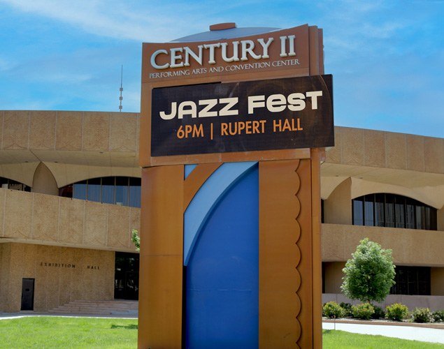 Century II Performing Arts and Convention Center monument sign with an LED display advertising Jazz Fest, with the venue building behind it.